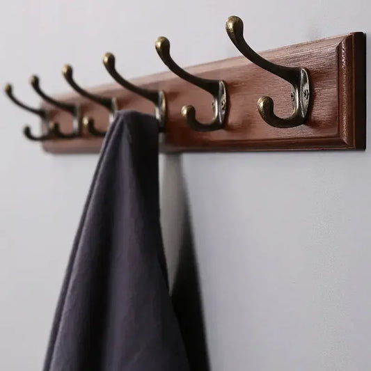 Porte-manteau mural en bois rétro foncé avec crochets doubles en bronze et vêtement suspendu