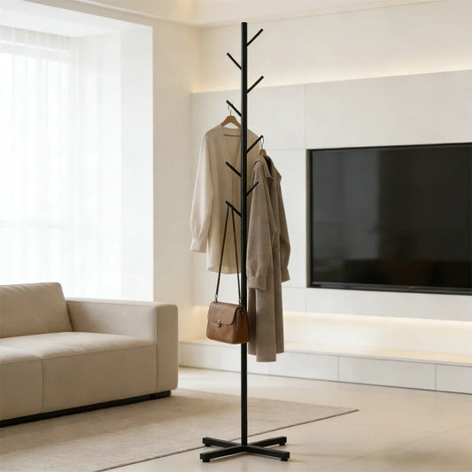 Porte-manteau sur pied noir en forme d'arbre à 8 crochets avec manteaux et sac suspendus dans un salon