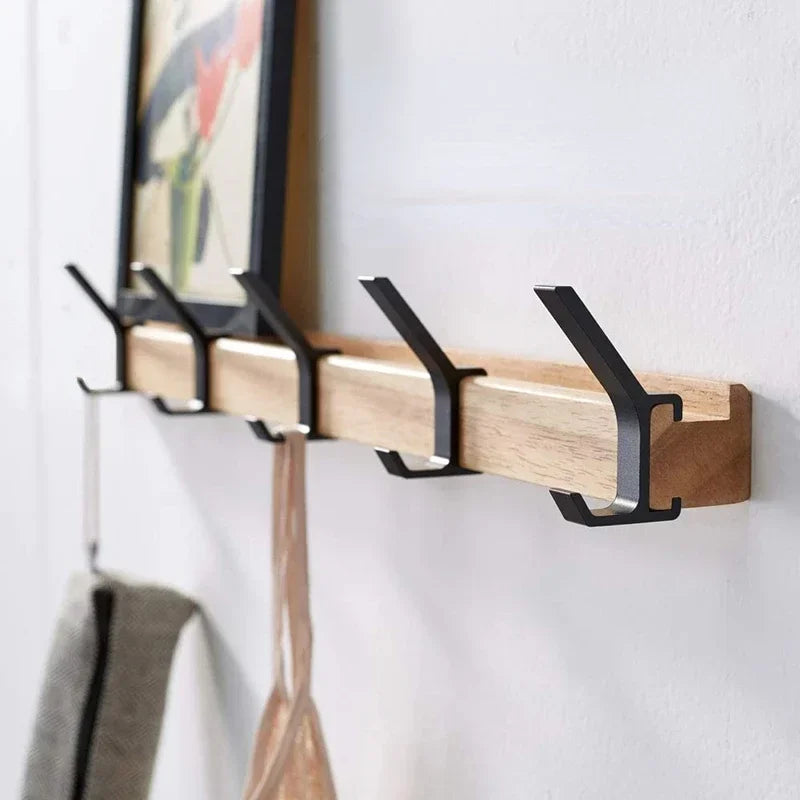 Porte-manteau mural nordique avec rail en bois clair et crochets noirs en métal, avec cadre au-dessus
