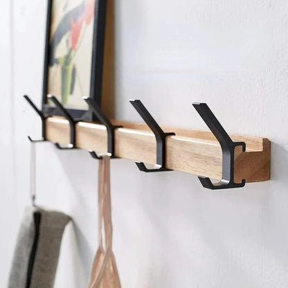Porte-manteau mural nordique avec rail en bois clair et crochets noirs en métal, avec cadre au-dessus