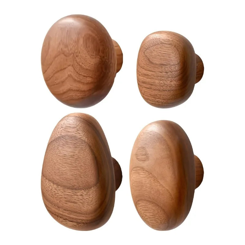 Quatre patères en noyer en forme de galets, de formes rondes et ovales différentes