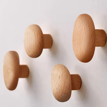 Quatre patères en hêtre clair en forme de galets, avec tige de fixation en bois